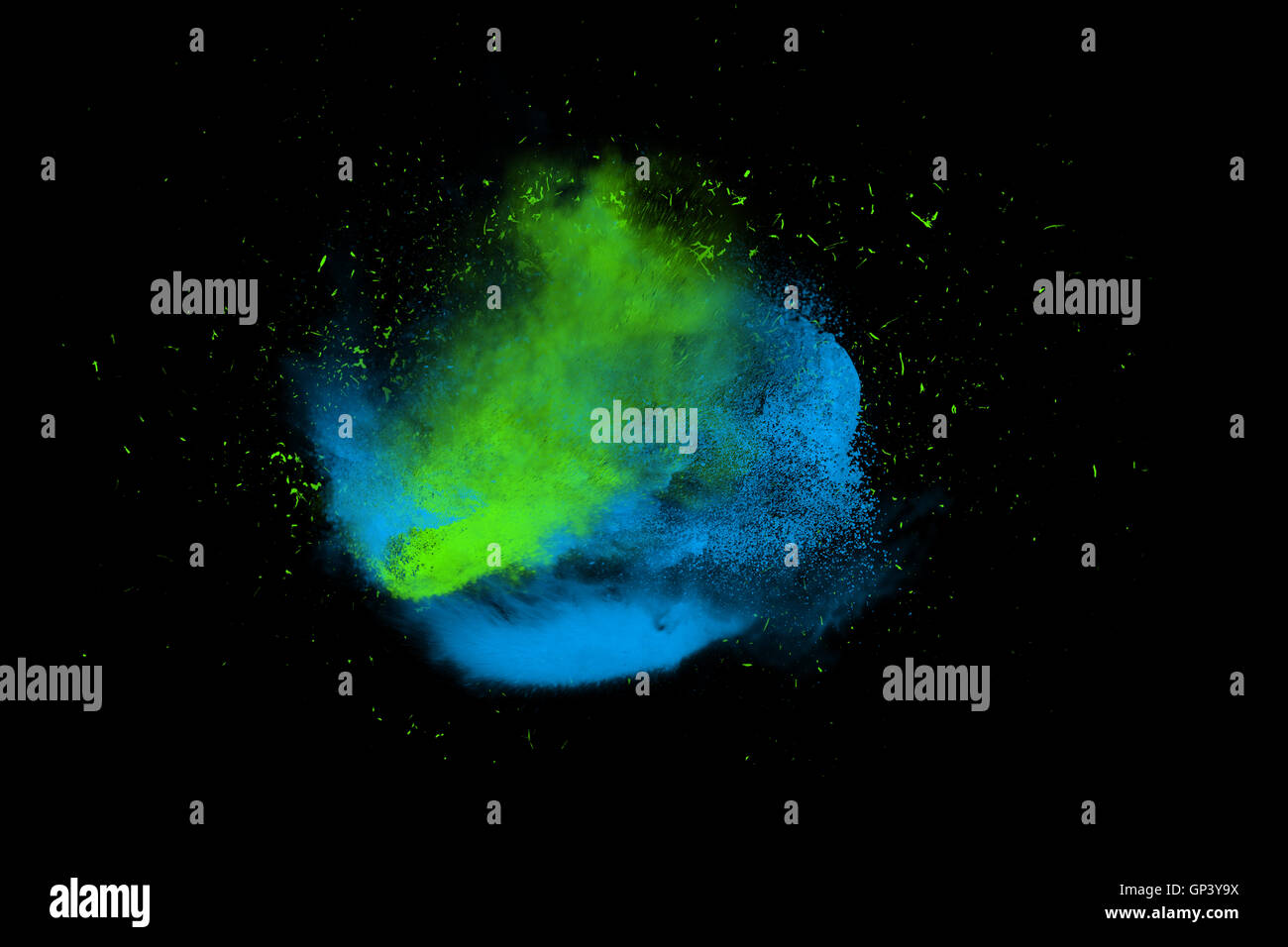 Freeze motion of blue and green powder paint exploding isolated on black, dark background. Abstract design of color dust cloud. Stock Photo