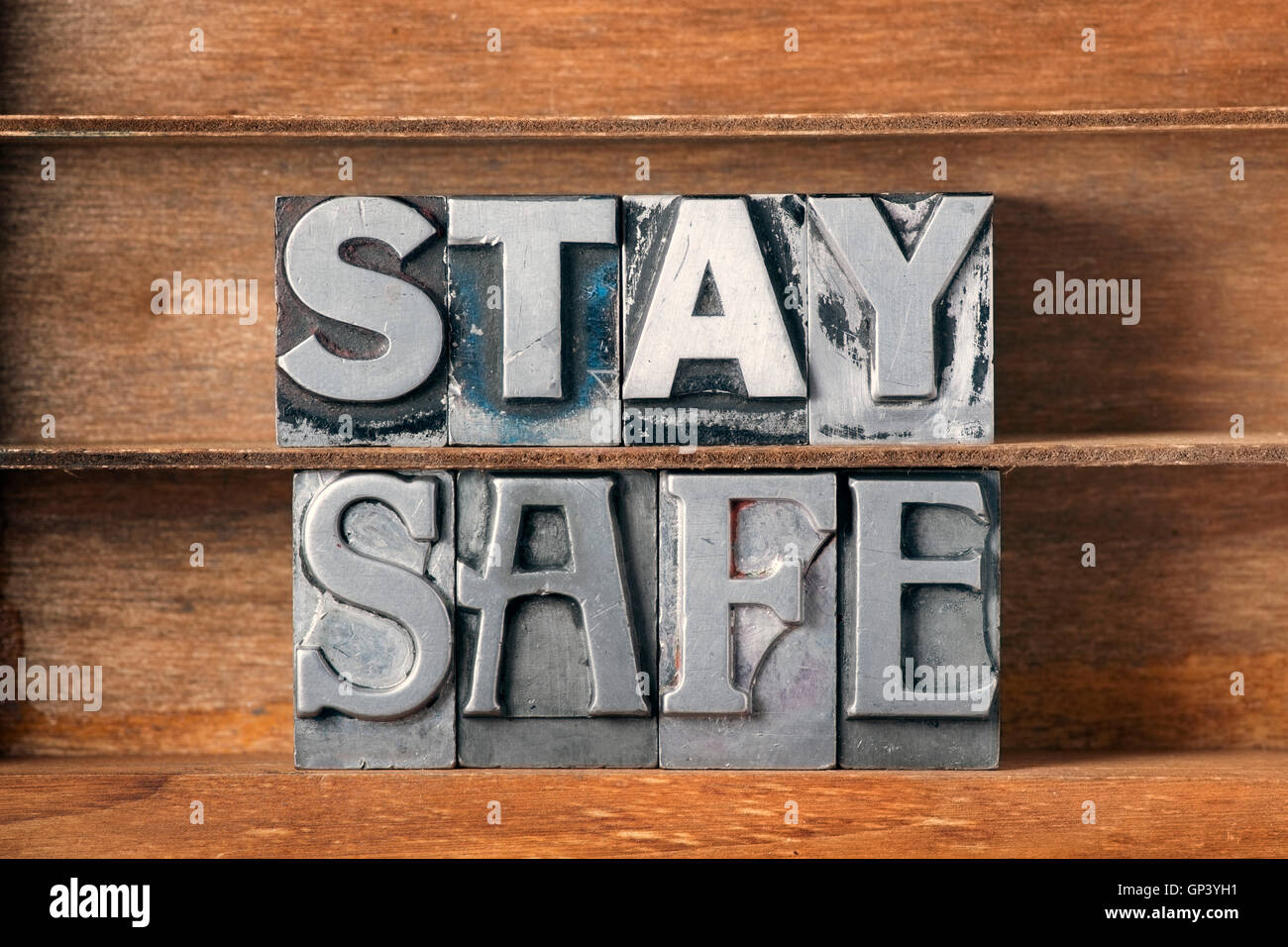 stay safe phrase made from metallic letterpress type on wooden tray Stock Photo