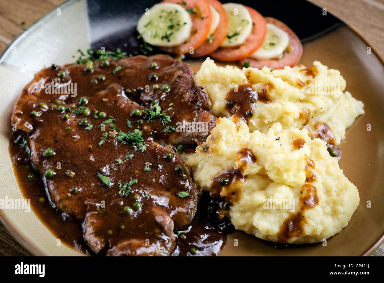 beef steak meal with mashed potato and gravy sauce on table Stock Photo