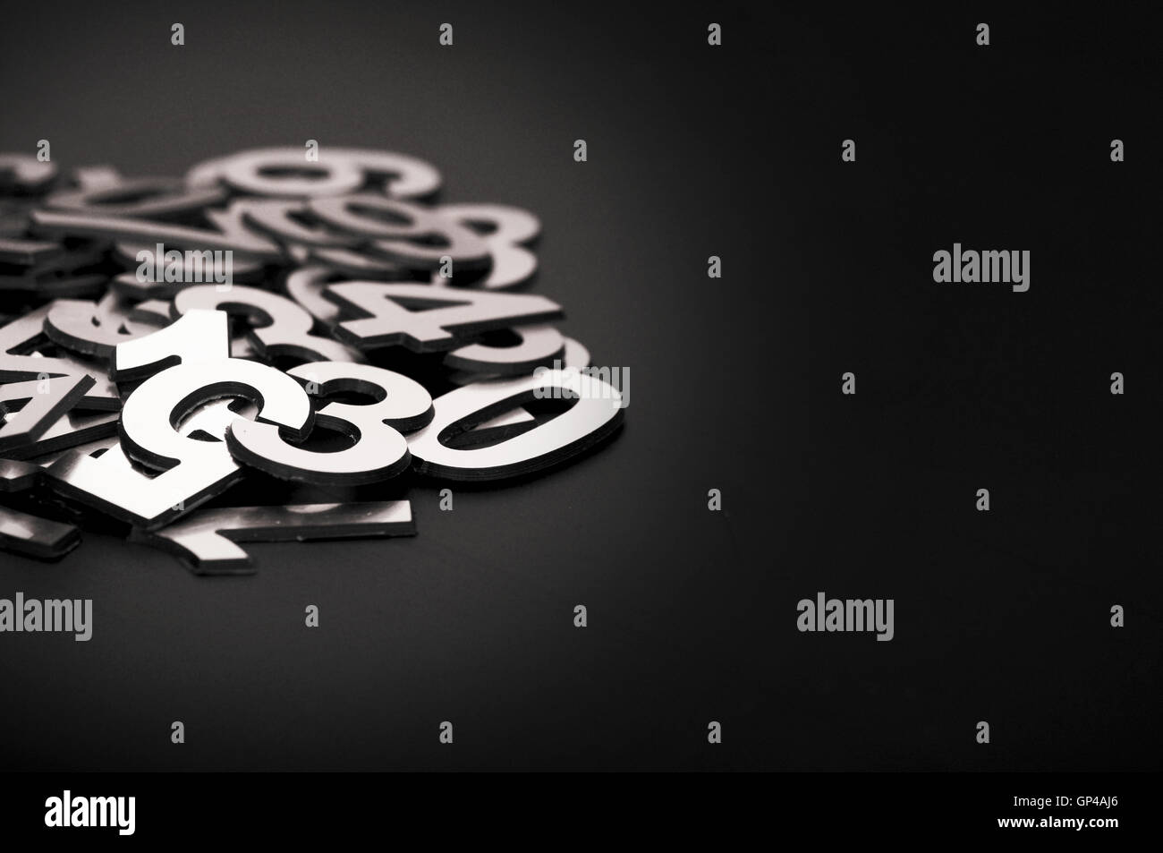 closeup image with pile metal numbers on black background, space Stock Photo