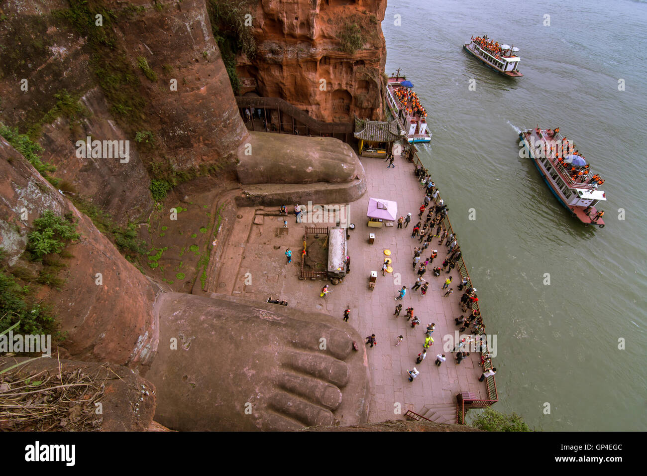 Tourists (on foot and by boat) at the Leshan Giant Buddha Scenic area, in Sichuan (China) Stock Photo