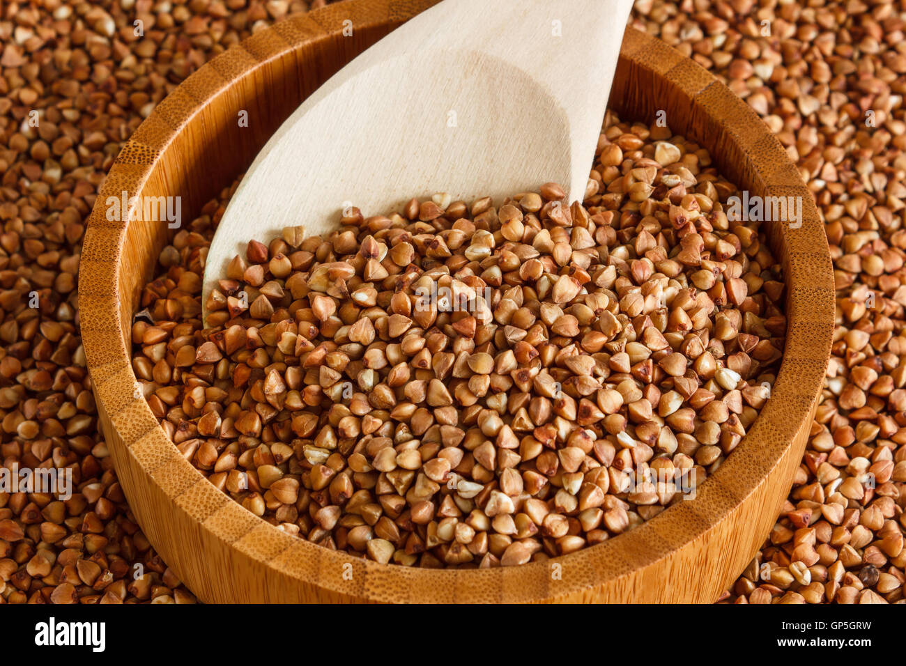 Buckwheat is on the plate with  wooden spoon Stock Photo