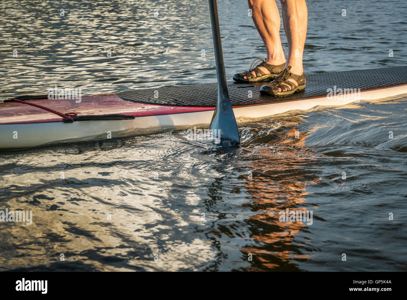 stand up paddling abstract - male feet on a paddleboard Stock Photo