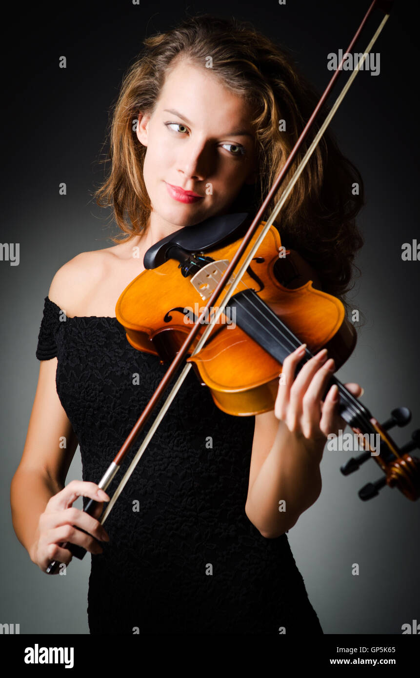 Woman with violin in dark room Stock Photo - Alamy