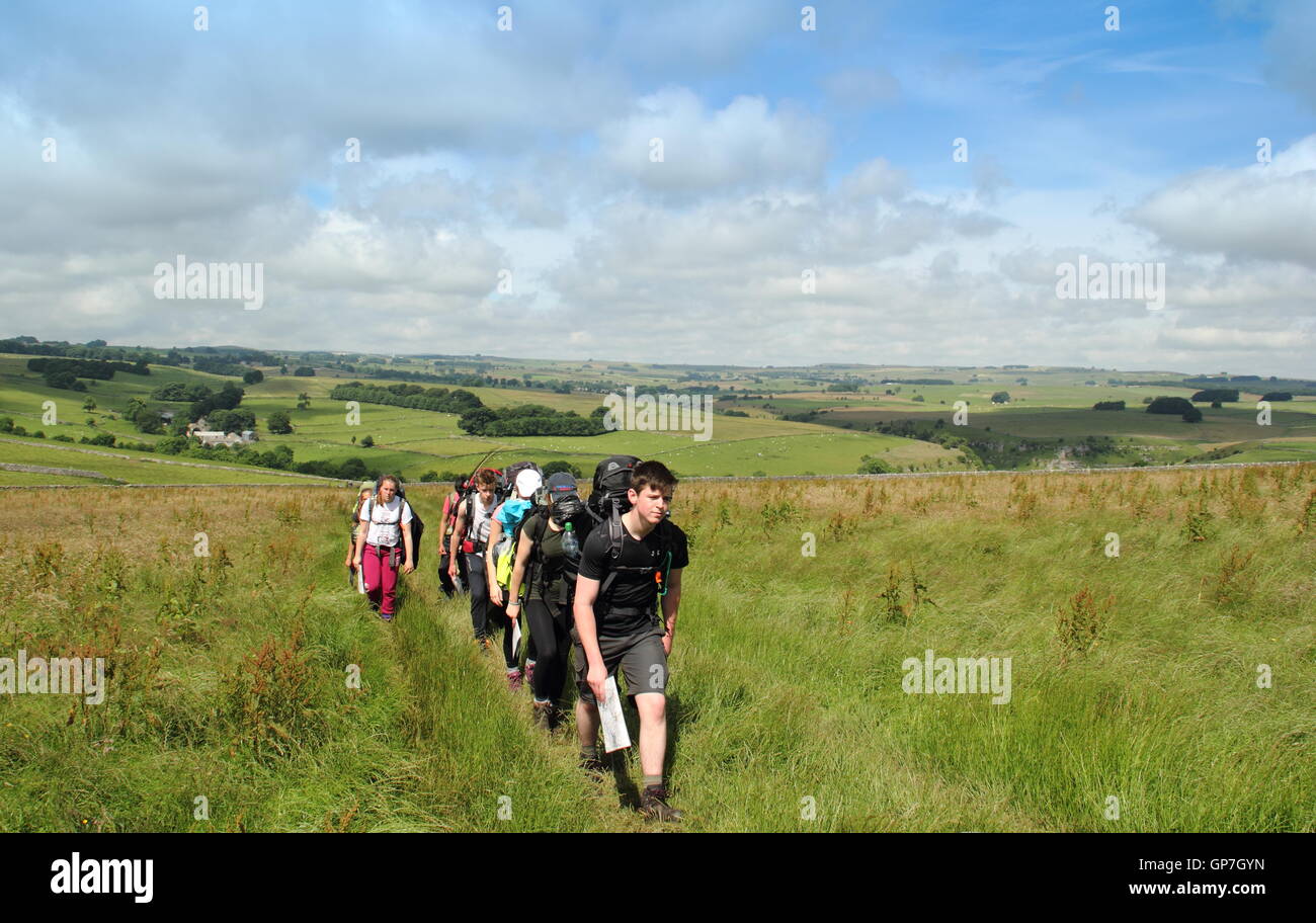 Walkers on a public path on the upper reaches of Lathkill Dale near Youlgrave in the Peak District National Park, UK - July Stock Photo