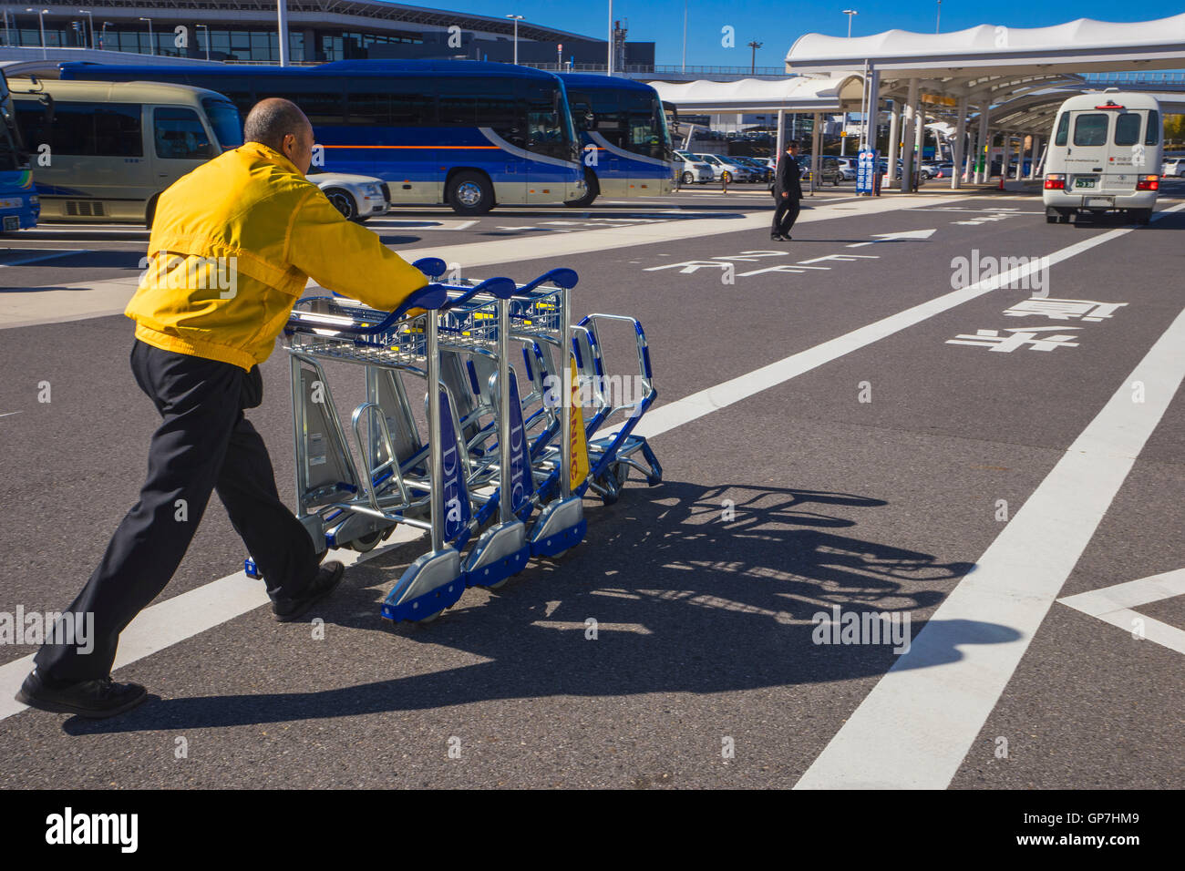 Man pushing luggage trolleys, narita international airport, tokyo, japan Stock Photo