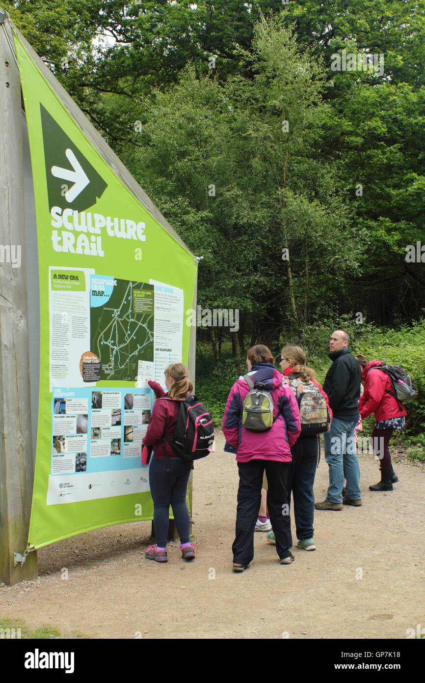 Visitors survey the information board at the start of the Sculpture Trail in the Forest of Dean, Beechenhurst, Gloucesterhire Stock Photo