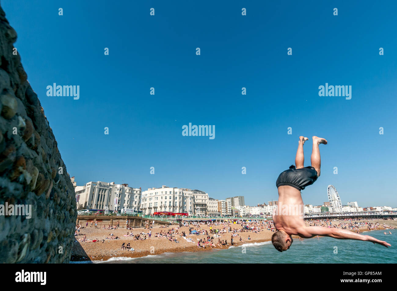 A teenager diving into the sea on Brighton seafront Stock Photo