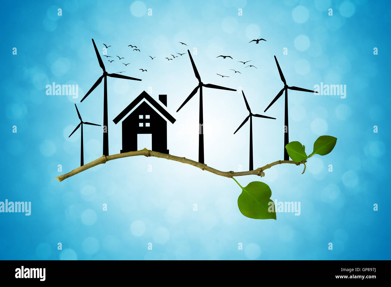 Environmental green energy concept. Silhouette of house, wind turbine and birds flying on a tree branch Stock Photo