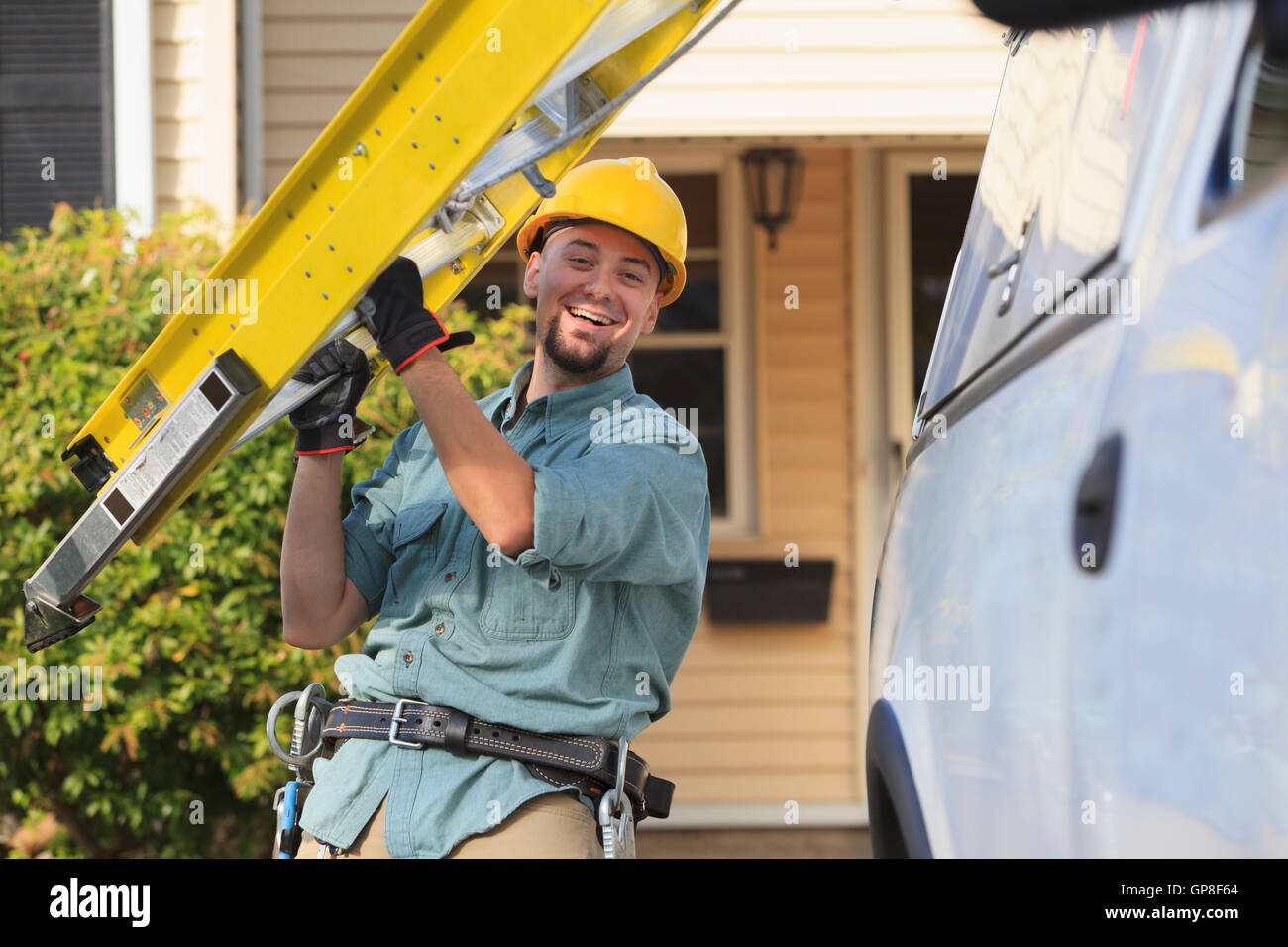 Lineman getting ladder from truck at site Stock Photo - Alamy