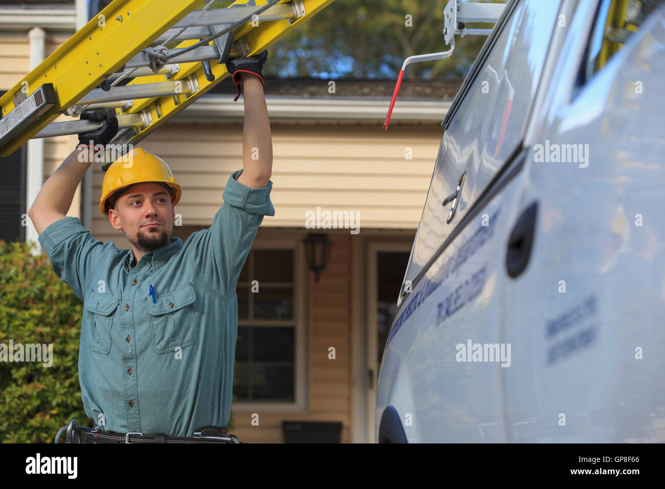 Lineman getting ladder from truck at site Stock Photo - Alamy