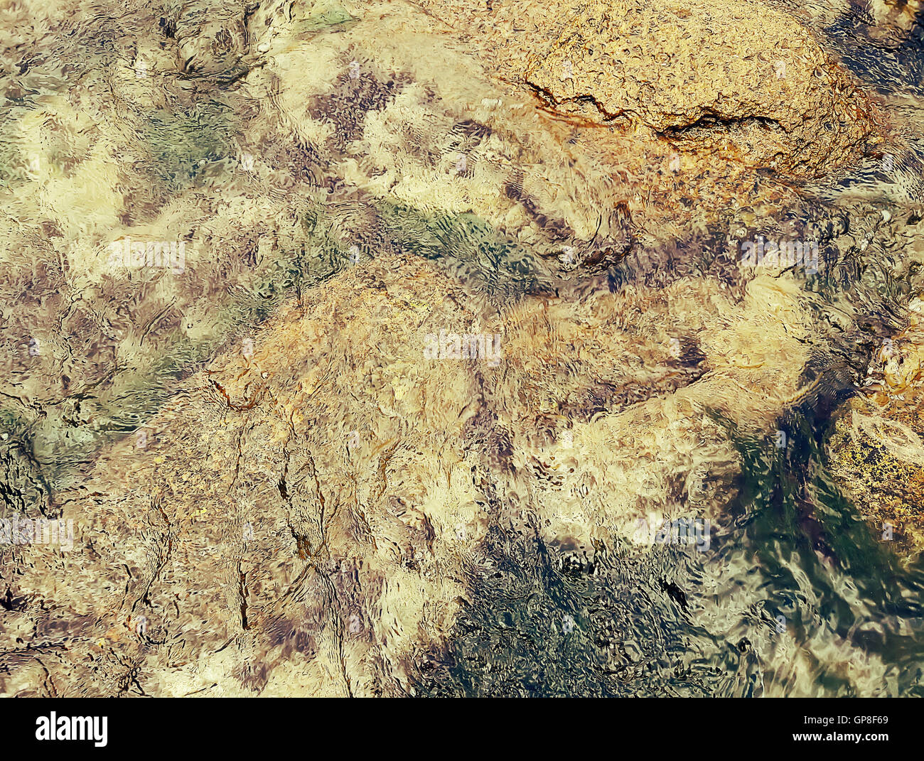 Golden underwater texture with the light on a rocky seafloor with stone pieces and moss Stock Photo