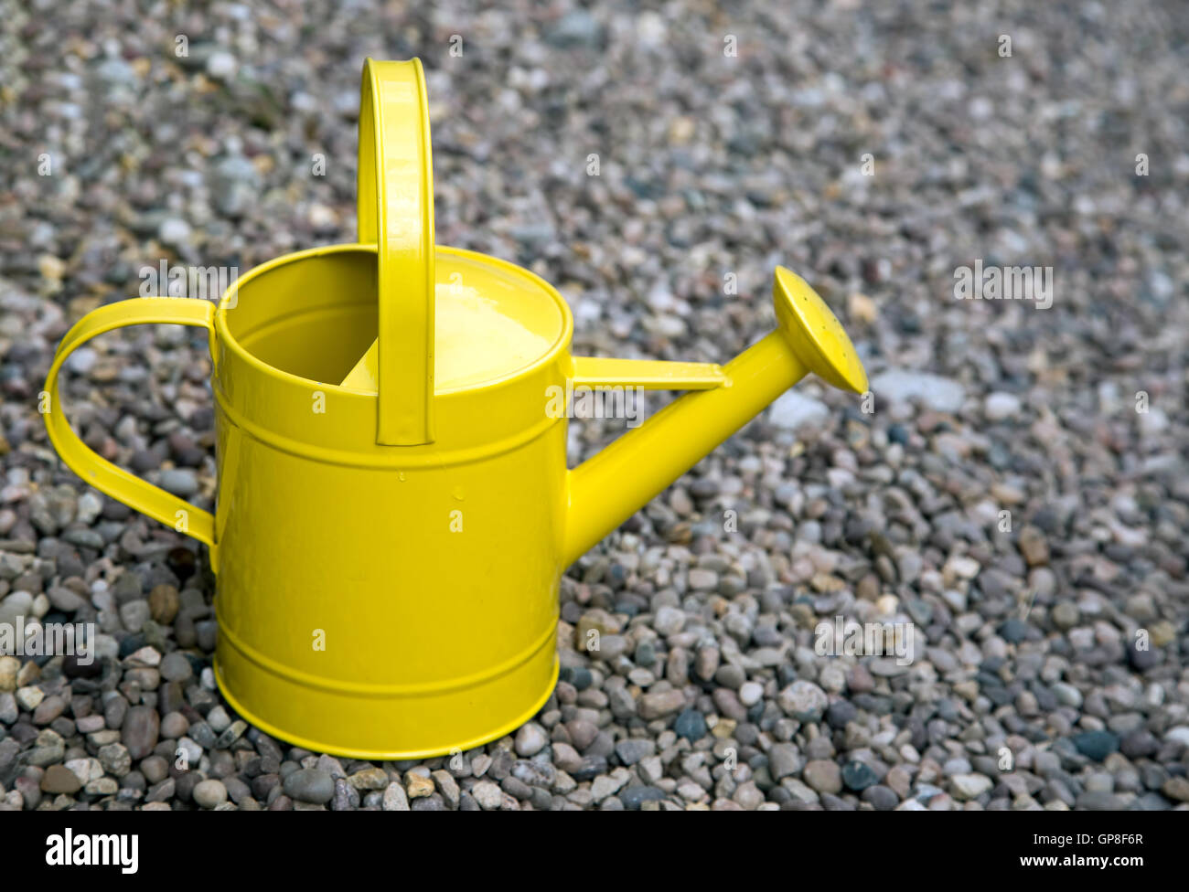 Bright yellow watering can on gravel Stock Photo Alamy