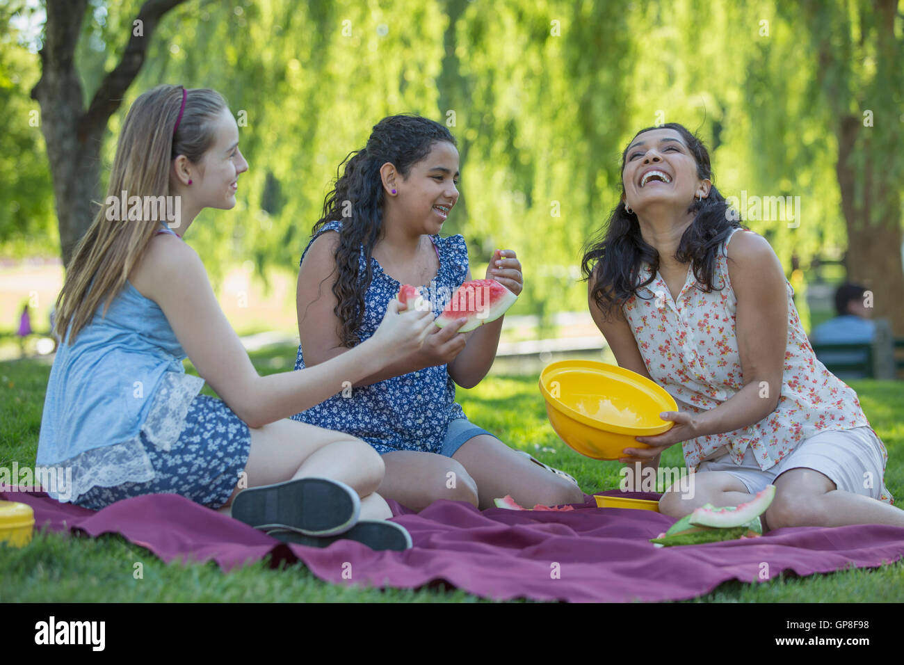 Happy Hispanic family having a picnic in the park Stock Photo