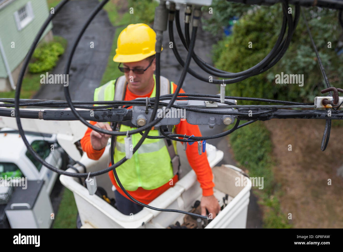 Cable lineman examining connections from bucket lift Stock Photo Alamy