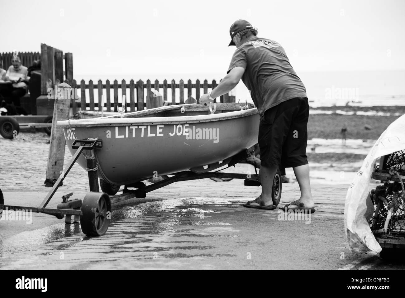 Fisherman gets his boat ready near the jetty in Robin Hoods Bay Stock Photo