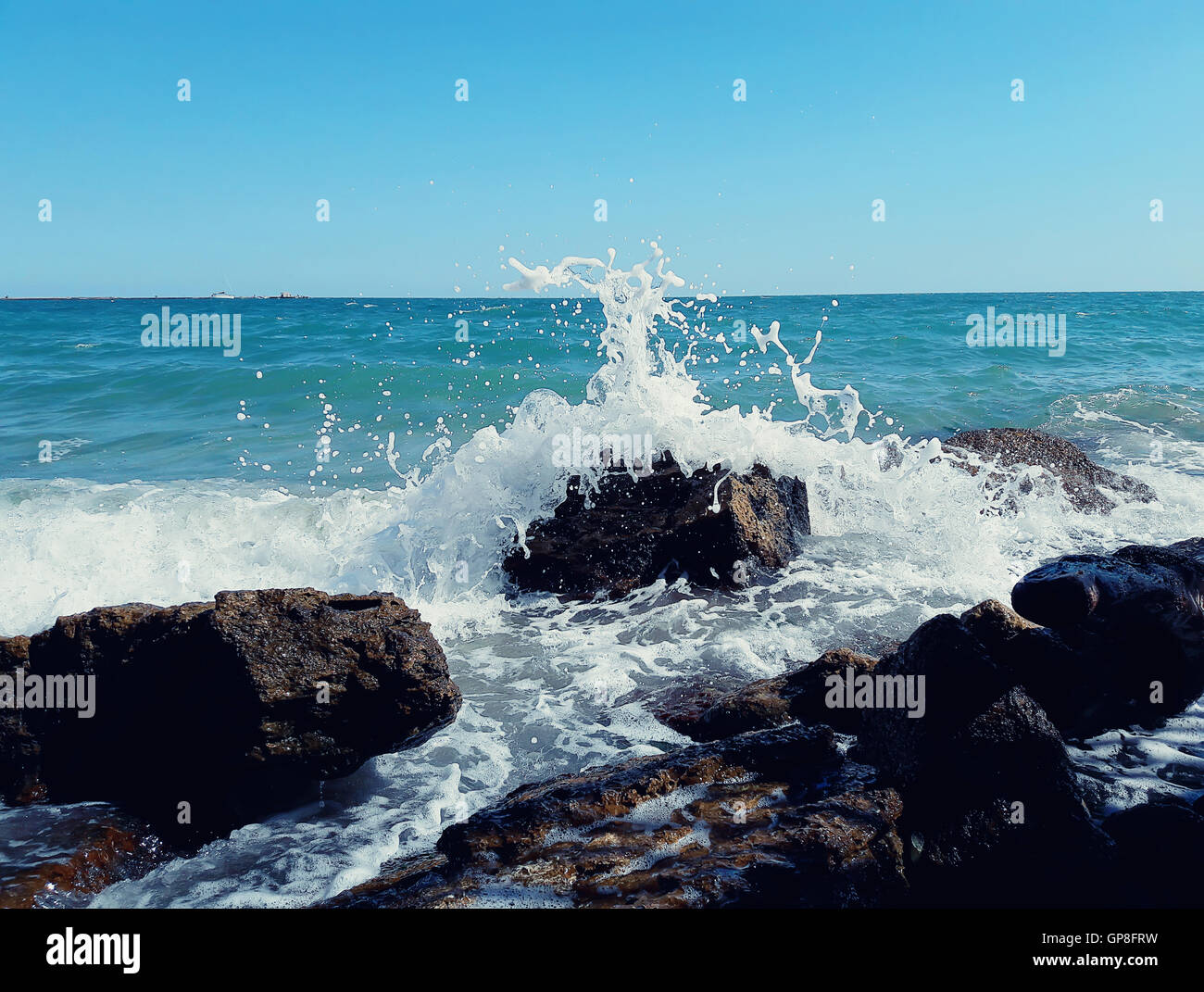 Big sea waves breaking on the stony beach forming foam and splash Stock Photo