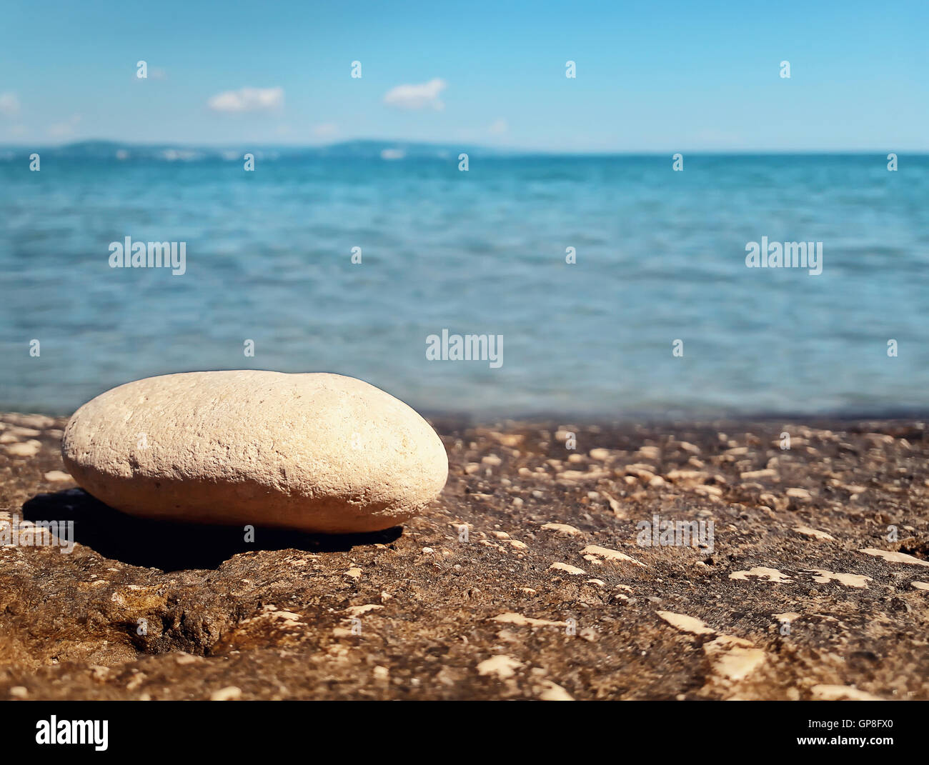 Closeup of pebble rock at the beach near the water. Journey, summer vacation concept Stock Photo