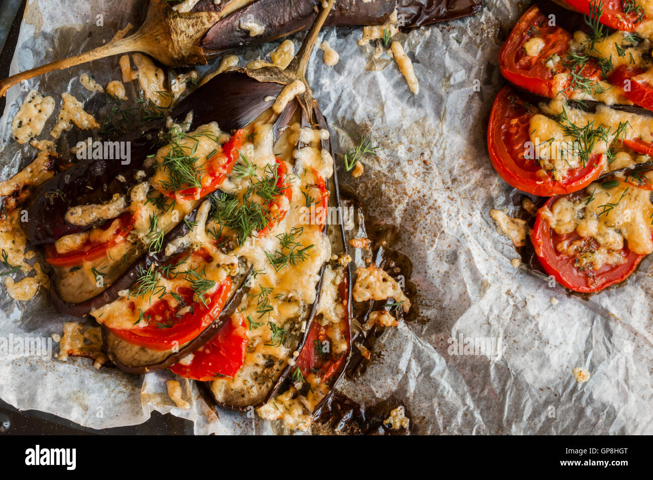 Baked eggplant in a fan shape on a baking sheet, top view. Cooked with