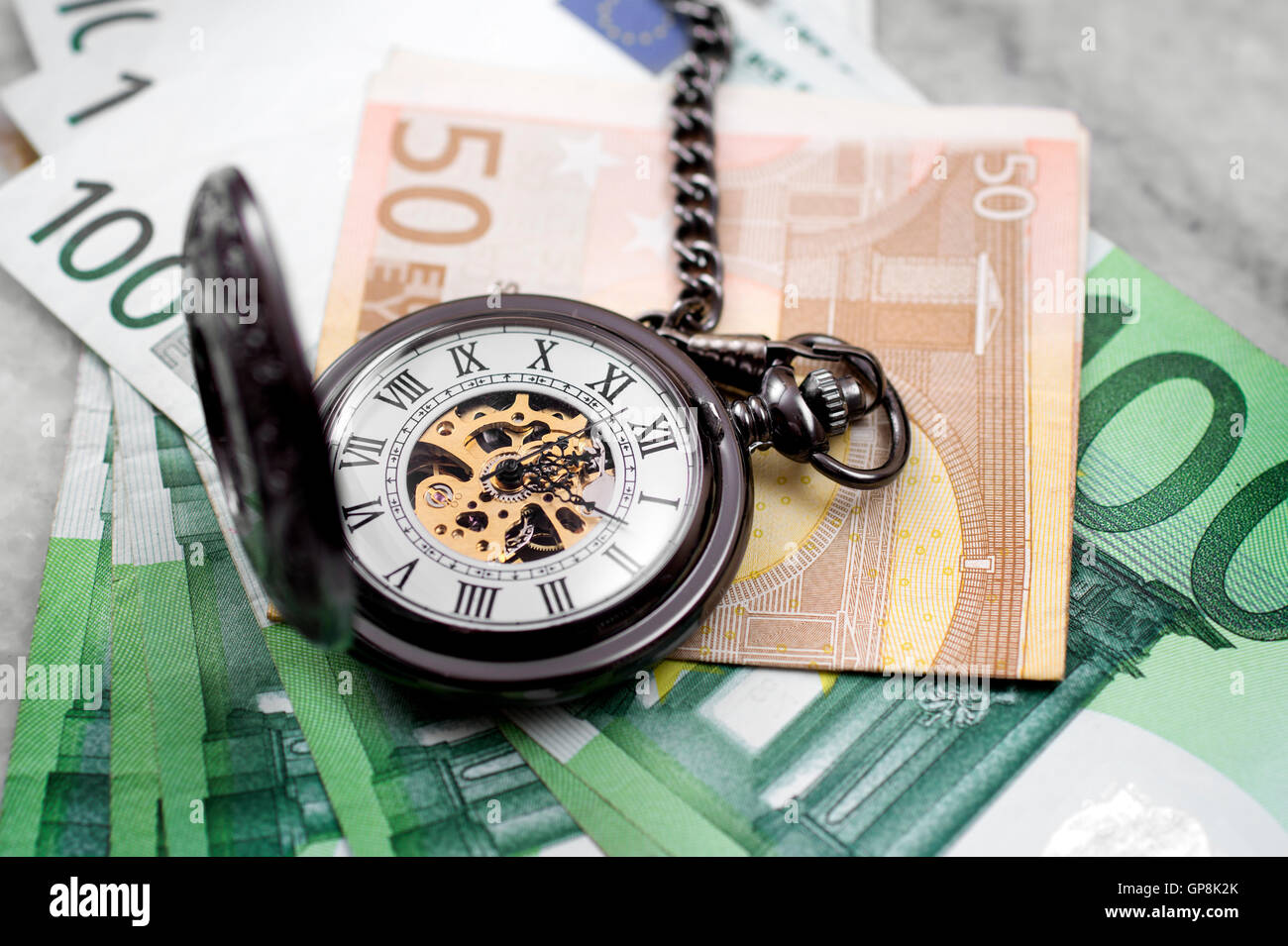 Time is money concept with euro banknotes and pocket watch Stock Photo