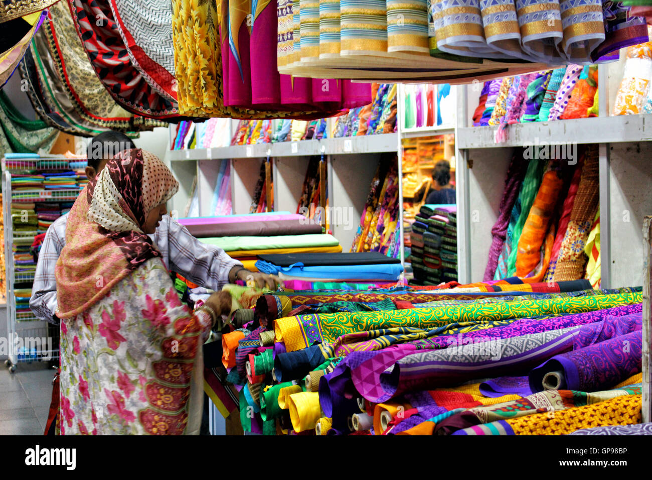 SINGAPORE/SINGAPORE - CIRCA NOVEMBER 2015: Lady with hijab buying colorful materials in Singapore's Little India district Stock Photo
