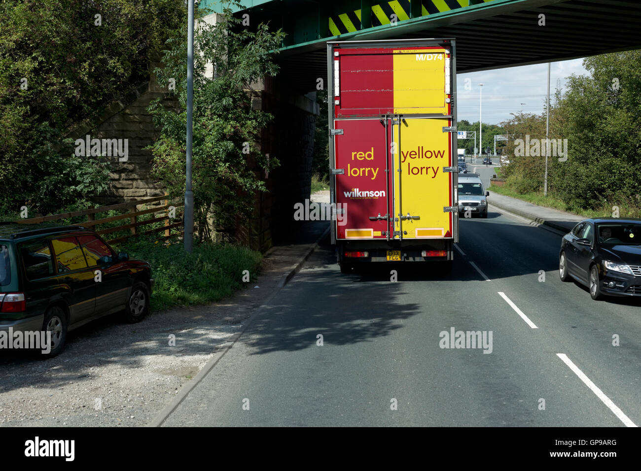 red,yellow,lorry,red lorry yellow lorry,driving under low bridge,pontefract,yorkshire,england,united kingdom Stock Photo