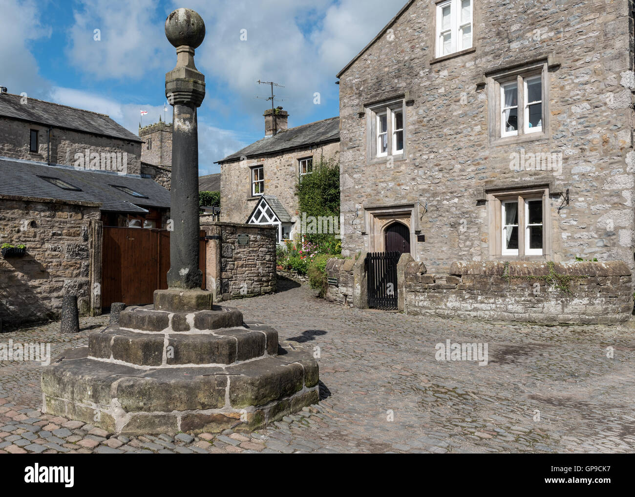 Ancient stone cross in the Swinemarket at Kirkby Lonsdale in Cumbria Stock Photo