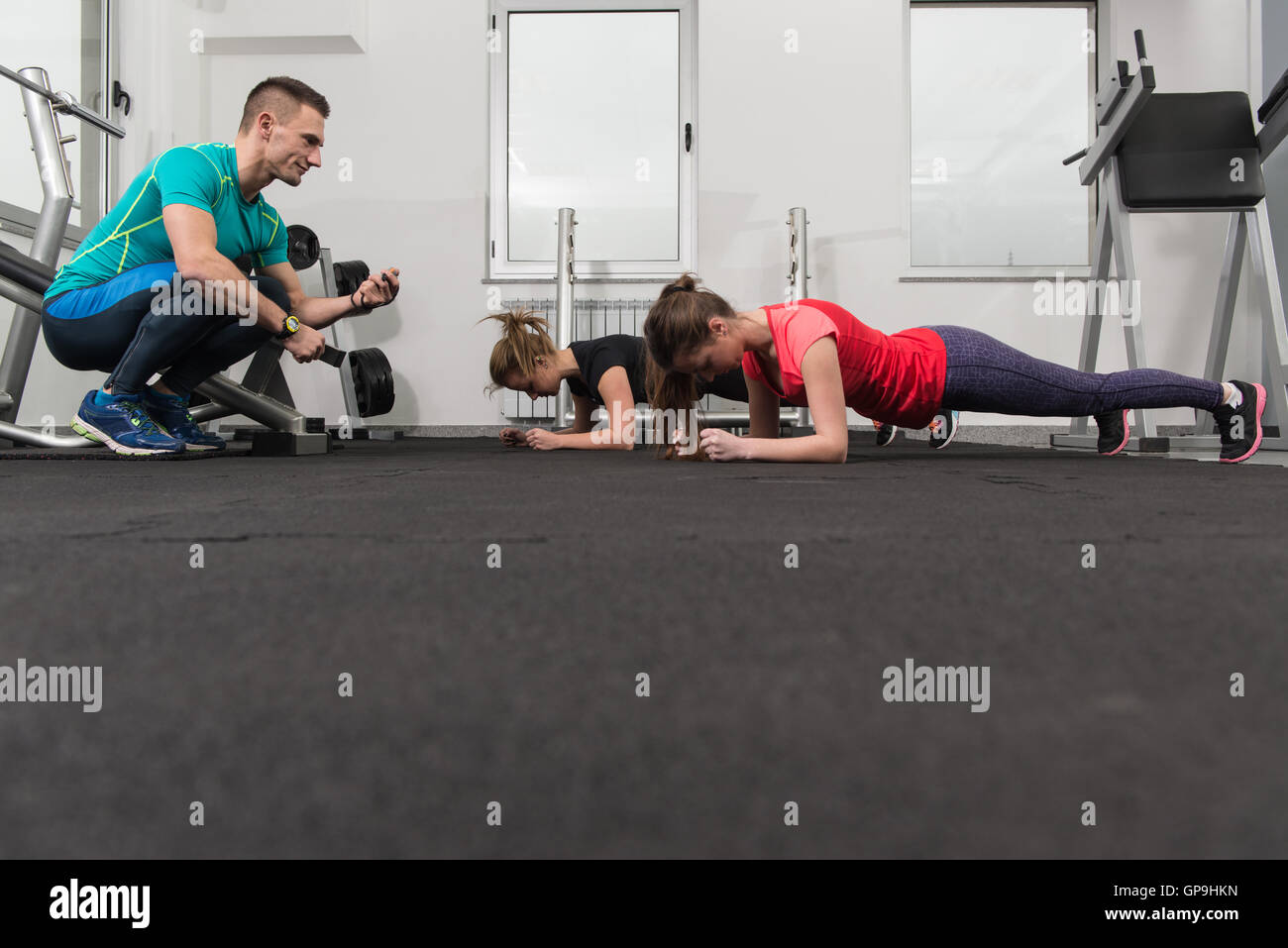 Group Of Young People Stretching In Gym For Better Fitness Led By