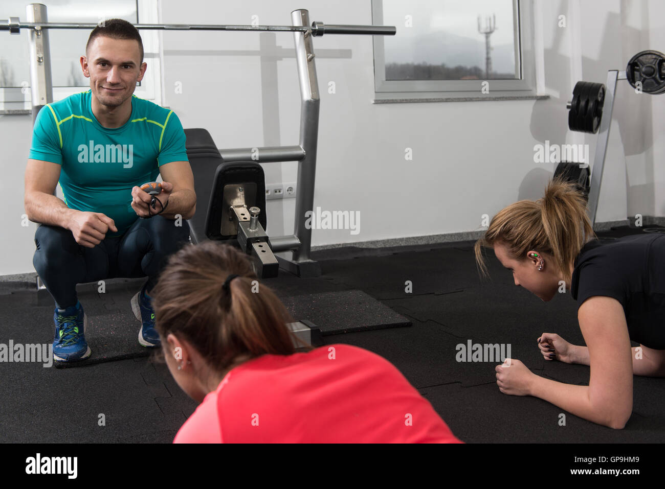 Group Of Young People Stretching In Gym For Better Fitness Led By