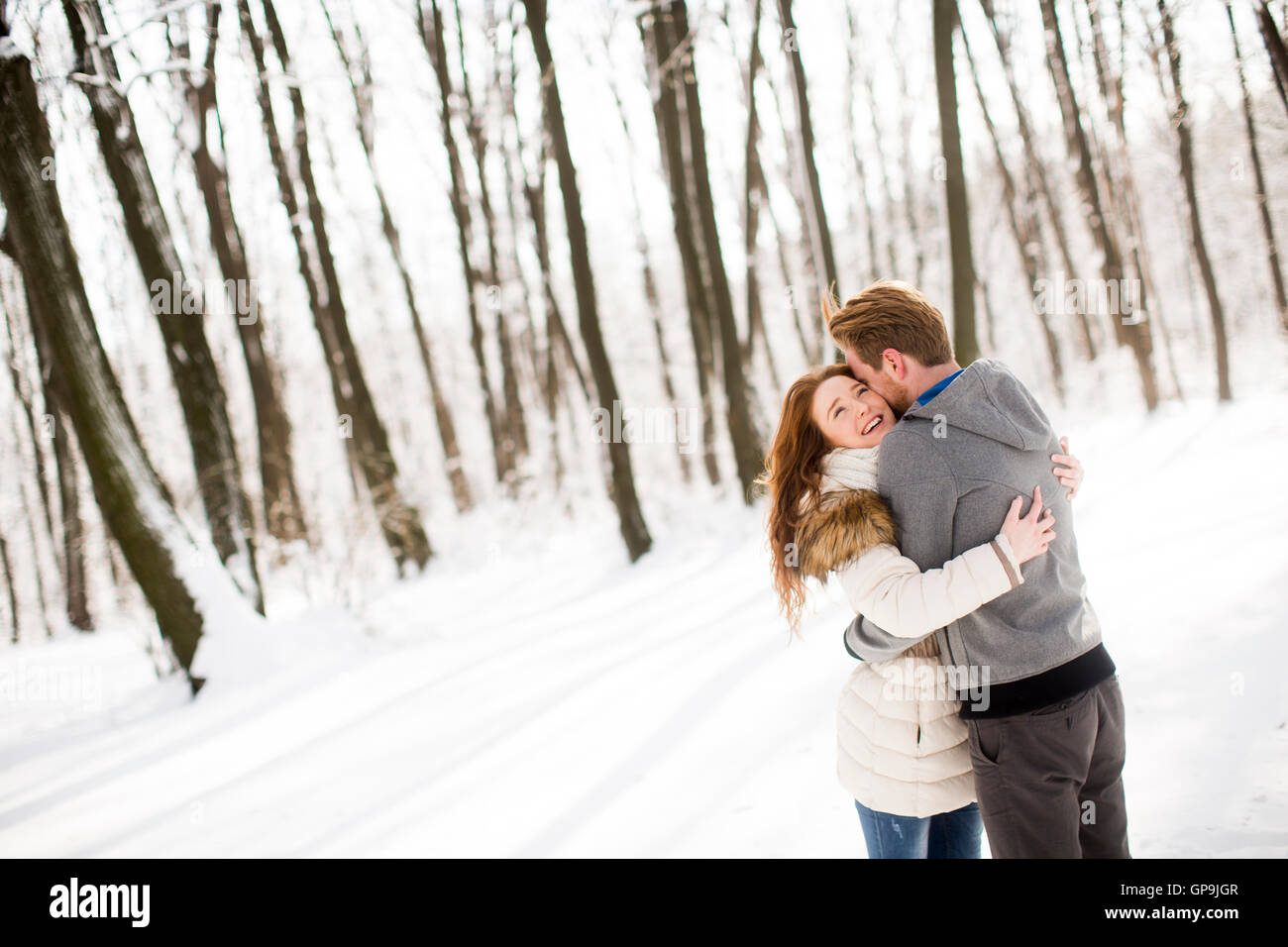 Loving young couple at winter forest Stock Photo - Alamy