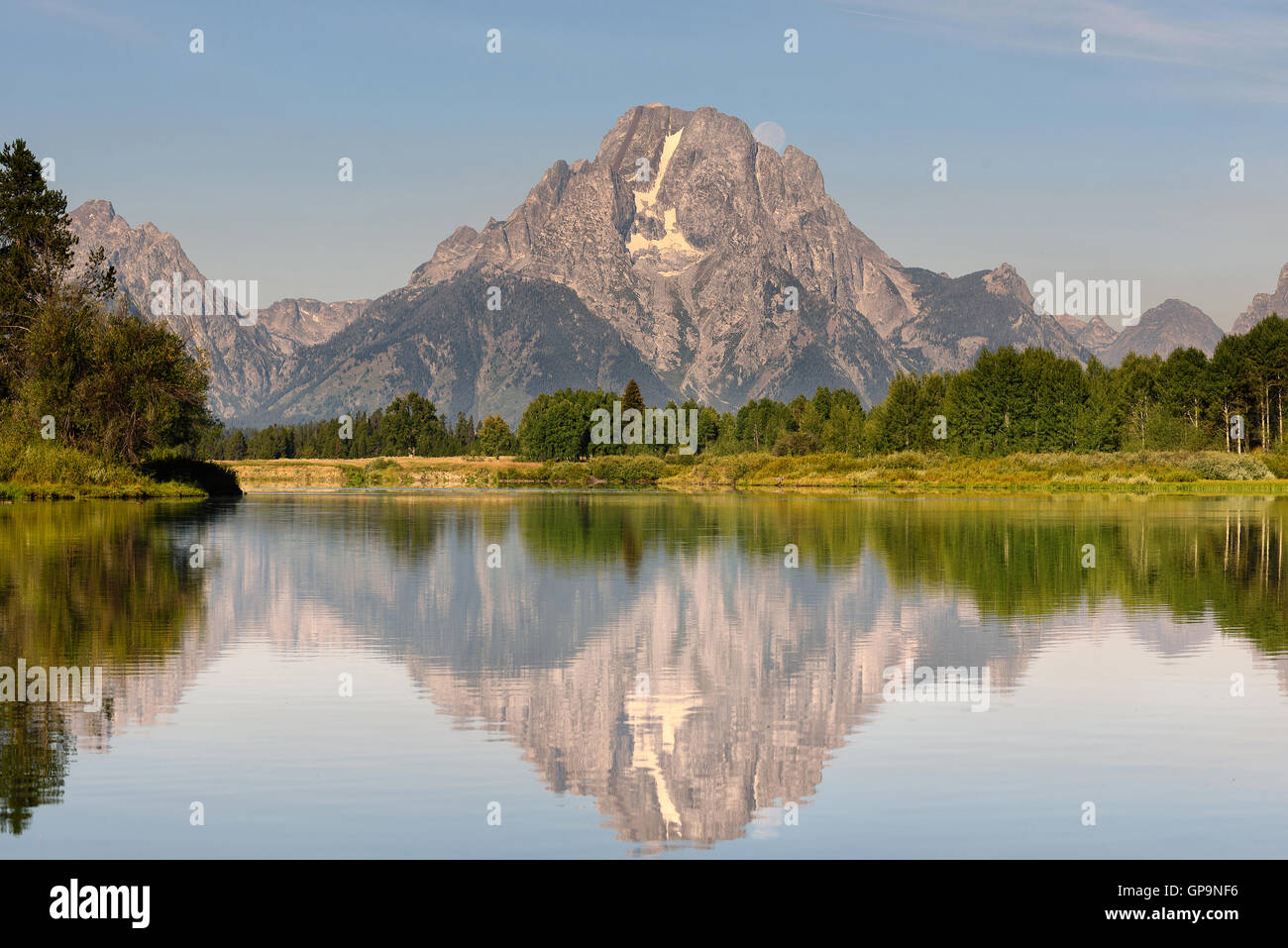 Beautiful Grand Teton mountain flecting on a smooth water surface with moonset behind the rock mountain. Oxbow Bend famous sceni Stock Photo