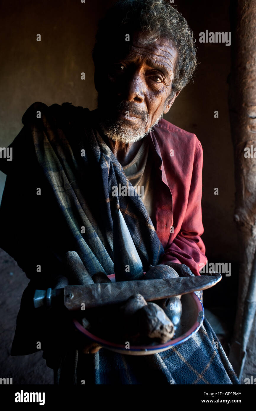 Traditional healer ('ombiasy') showing pieces of wood and a knife he uses to cure local people ( Madagascar) Stock Photo