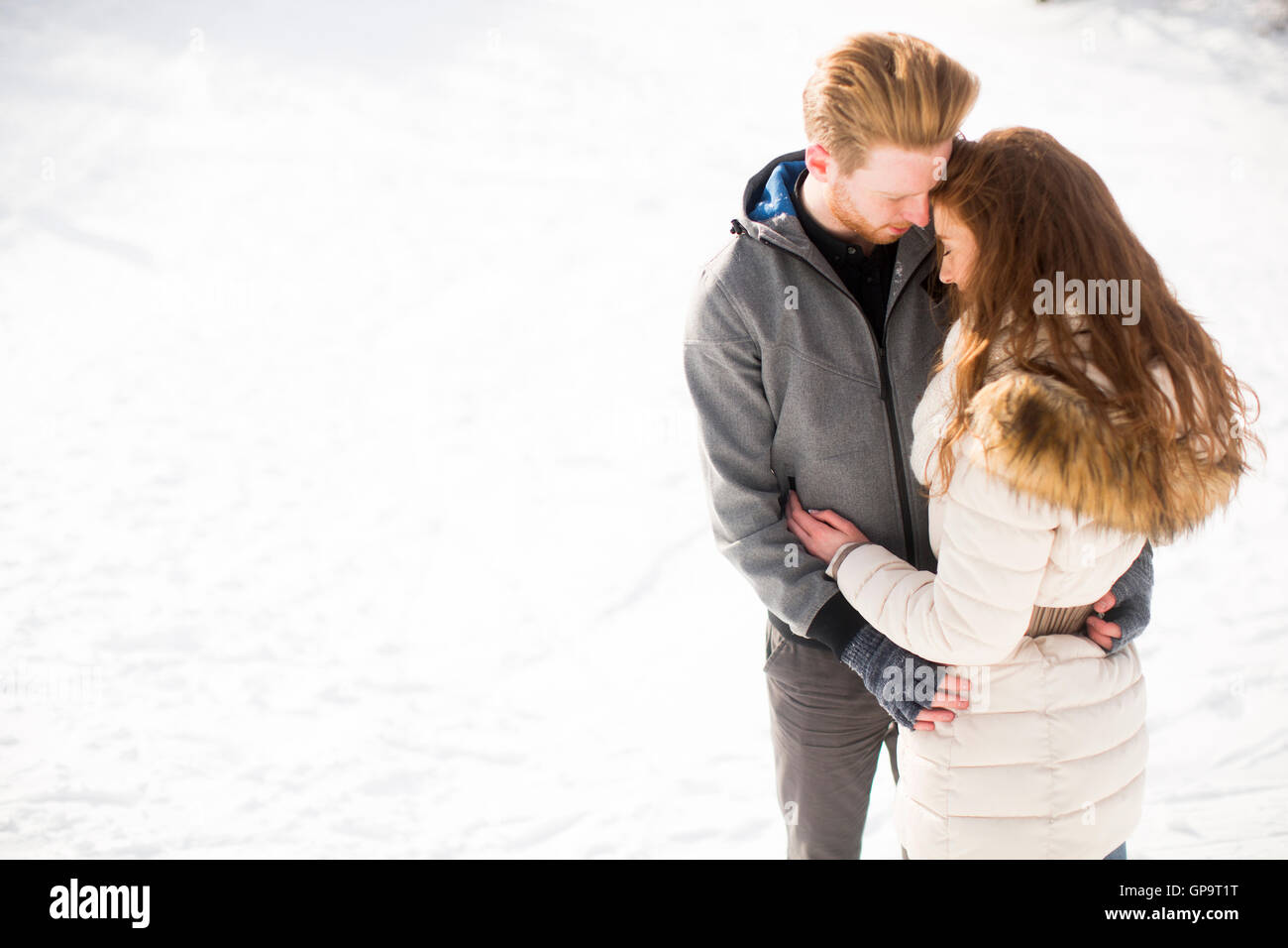 Loving young couple at snow in the winter forest Stock Photo