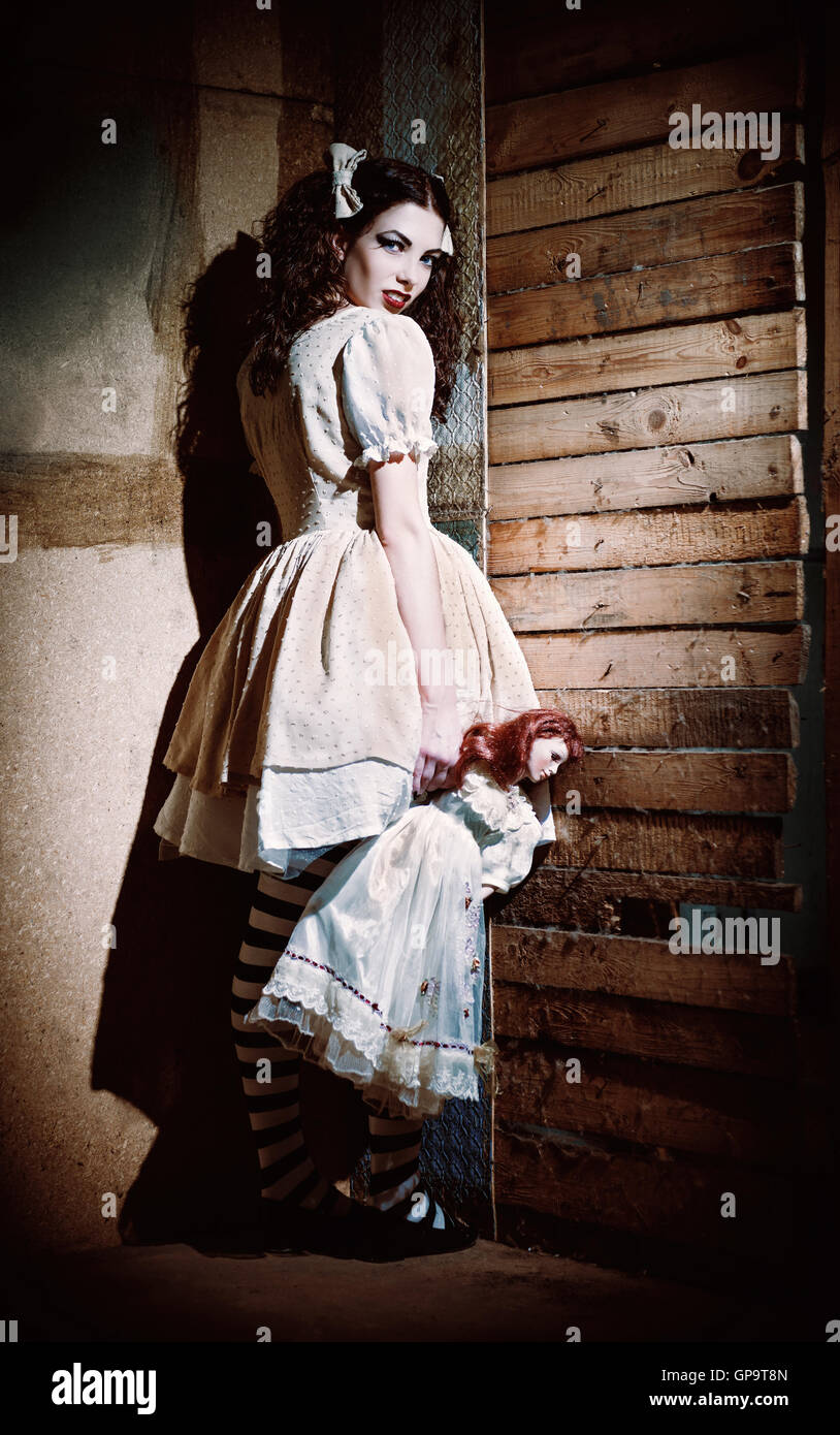 Portrait of a weird scary girl with doll in hand Stock Photo Alamy