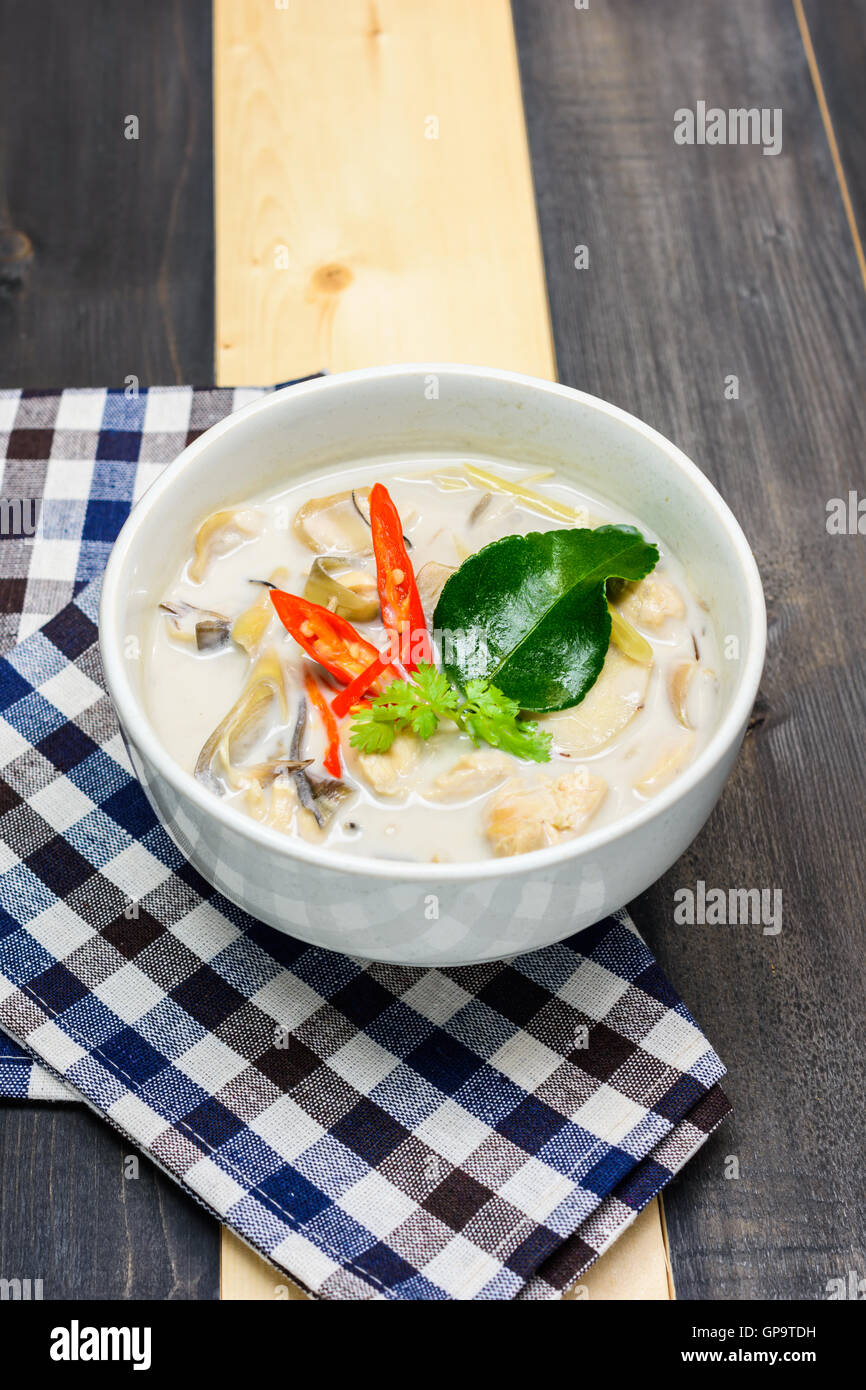 coconut milk soup with chicken or Thai chicken coconut Soup ( Tom Kha Gai ) on wooden with table cloth, table top view, Thai loc Stock Photo