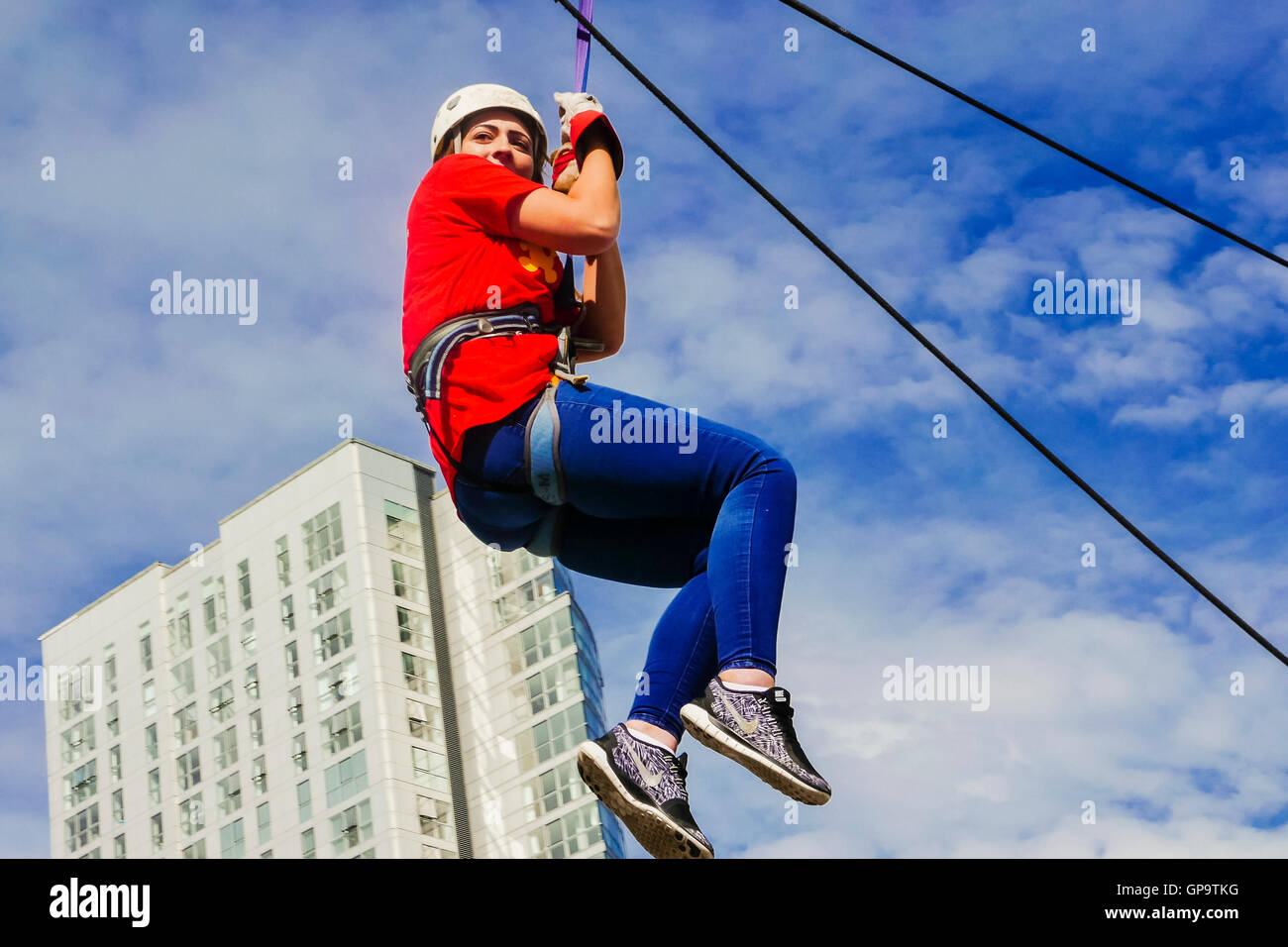 A young woman abseils from a tall building for charity Stock Photo