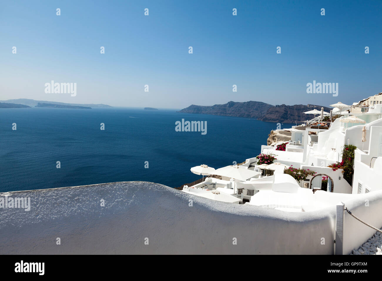 Traditional white buildings on the vibrant, hot and sunny Greek Island of Santorini set against a beautiful blue sky. This is a popular holiday destiny Stock Photo
