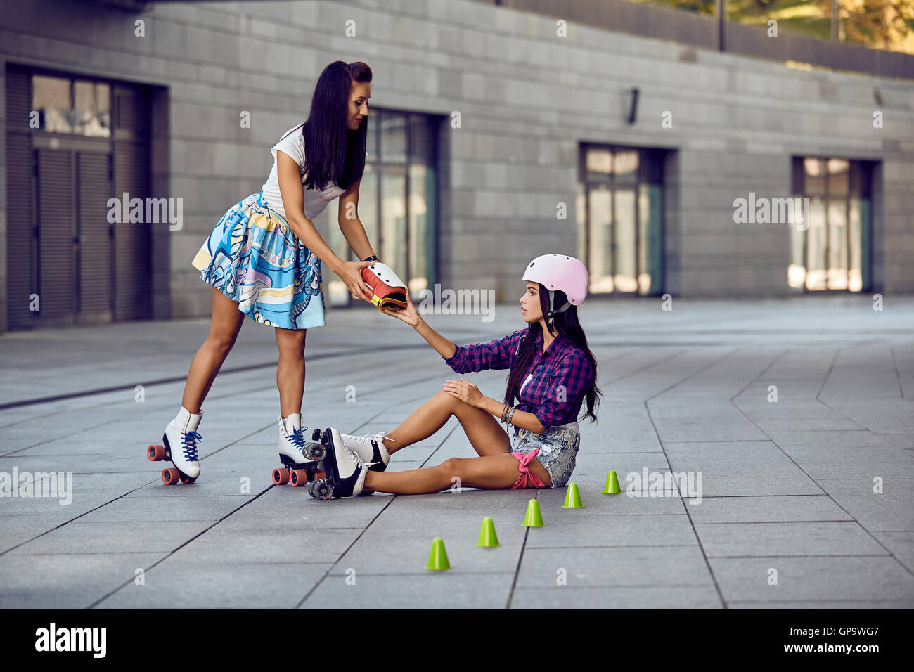 Girl fall down and scratch the leg after rollerblading Stock Photo