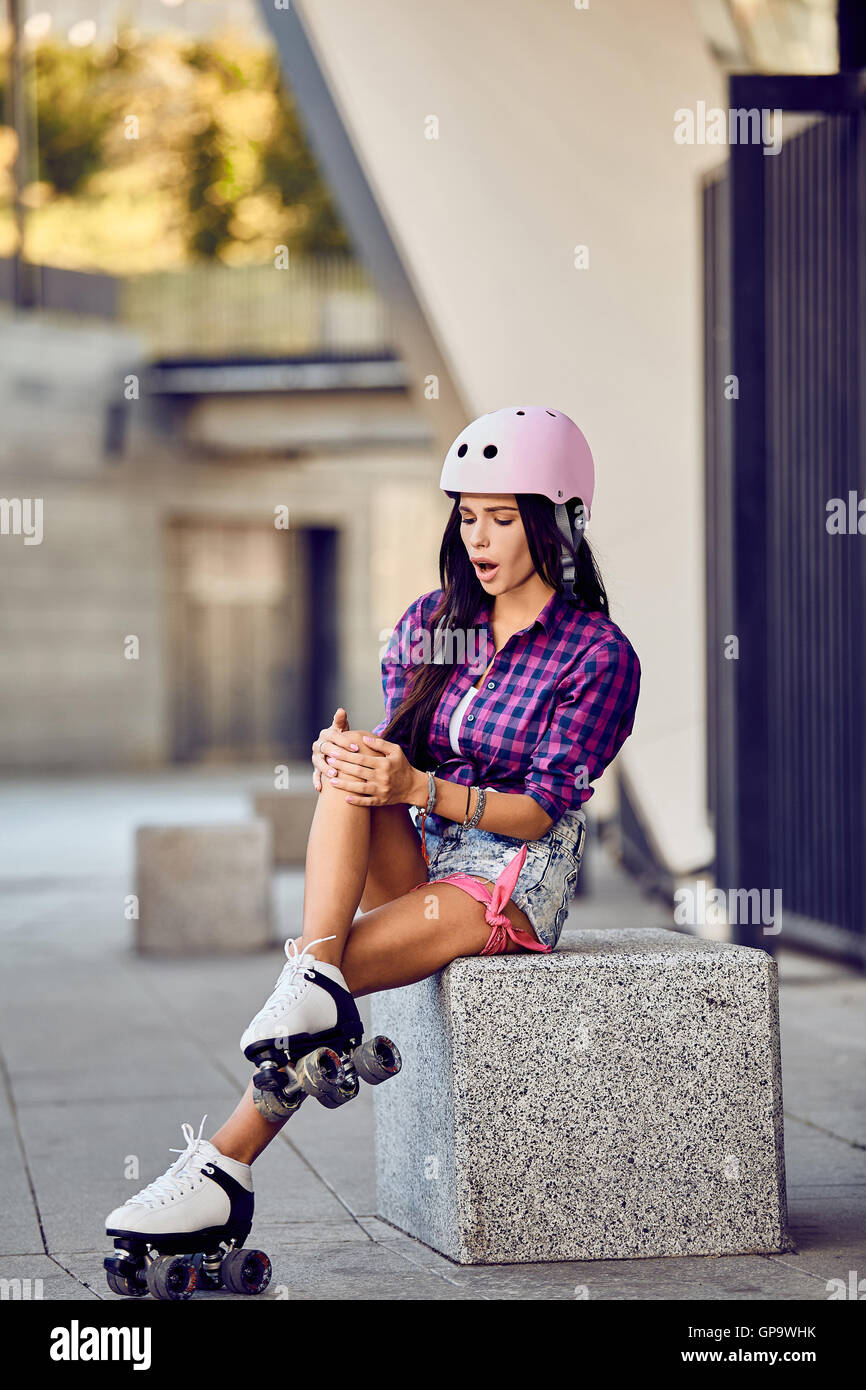 Stylish beautiful girl fit her knee during rollerblading Stock Photo