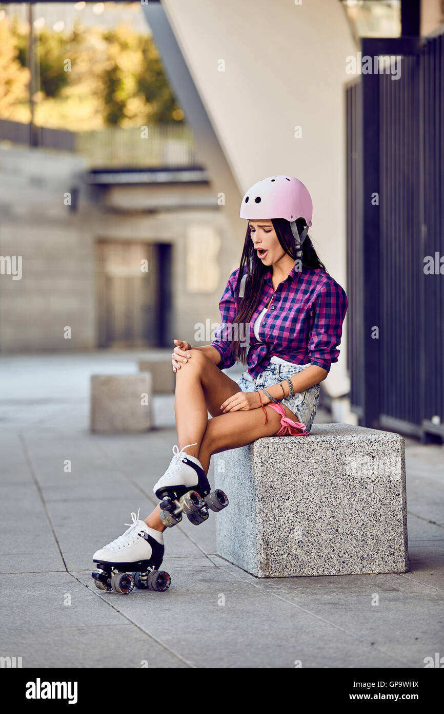 Girl hit a leg while roller skating in urban skate park Stock Photo - Alamy