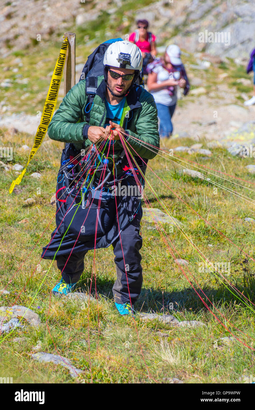 Man with parachute getting ready to fly, Nid d'Aigle, Chamonix, France Stock Photo