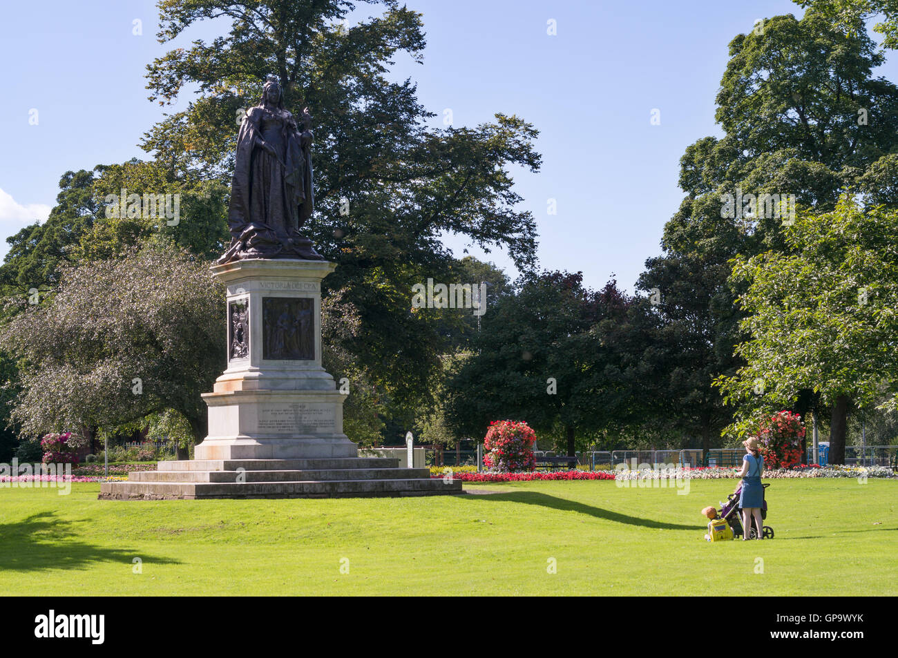 A young woman with children looking at the statue of Queen Victoria, in