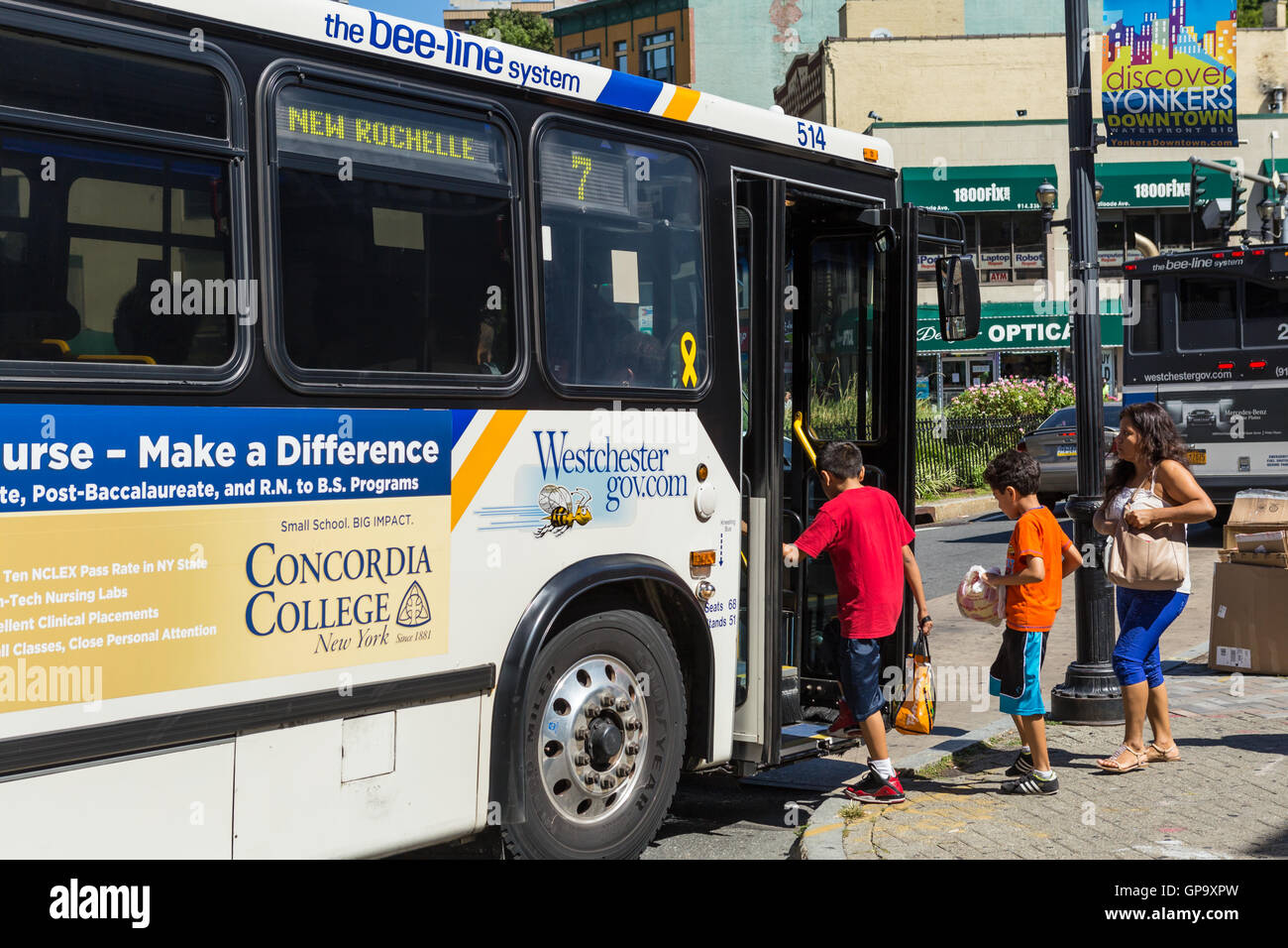 Passengers board a Westchester County Bee-line System bus at a bus stop in Yonkers, New York. Stock Photo