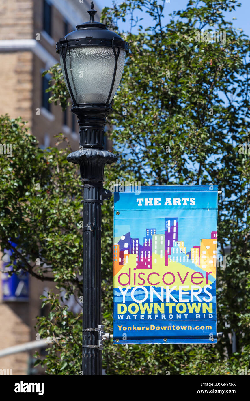 A banner promoting the Yonkers Downtown Waterfront Business Improvement District hangs from a lamppost in Yonkers, New York. Stock Photo
