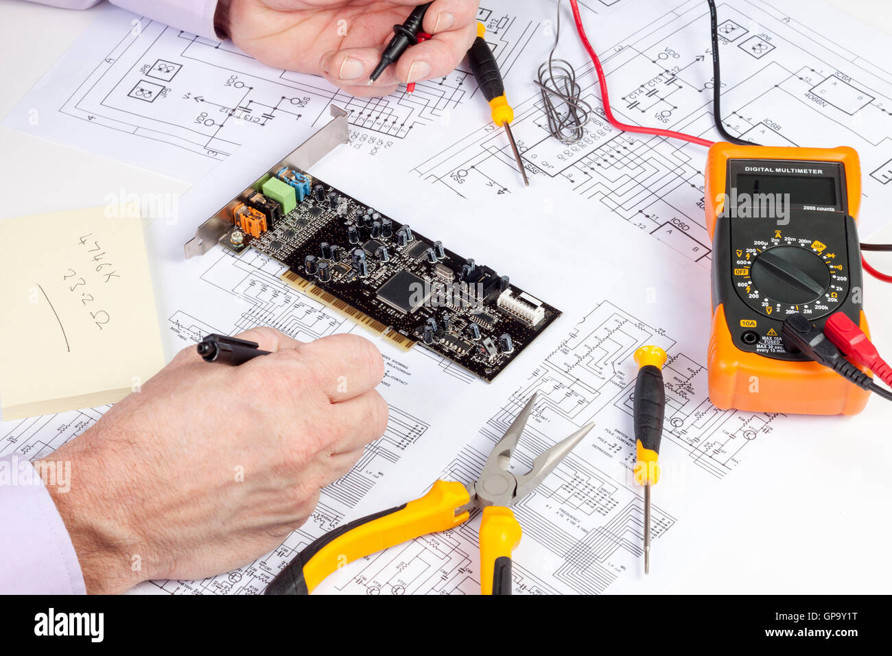 Electronics engineer making changes to a computer circuit wiring diagram Stock Photo