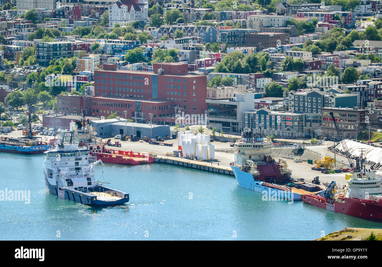 Commerce, trade, cargo and ships of all kinds lined up along St John's Harbour in Newfoundland Canada. Stock Photo