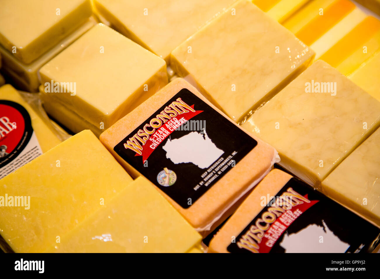 A display of packaged Wisconsin cheddar cheese in the refrigerator case of a grocery store Stock Photo