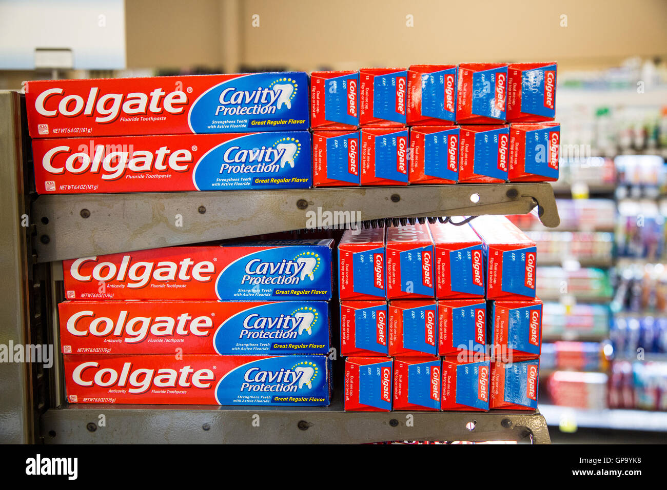 Stacks of Colgate toothpaste boxes on display on shelves at a grocery ...