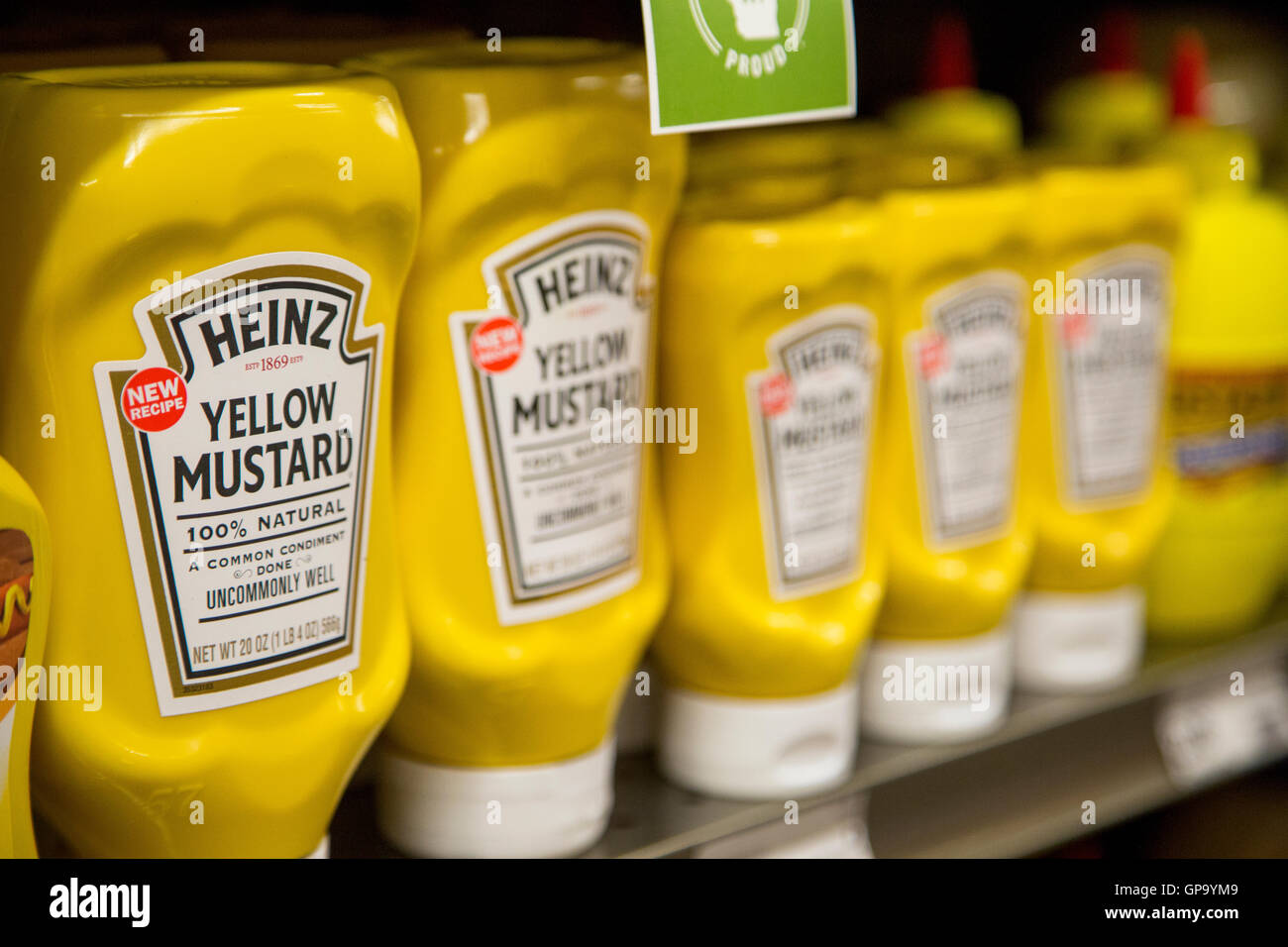 A row of Heinz yellow mustard plastic squeeze bottles on the shelf of a grocery store. Stock Photo