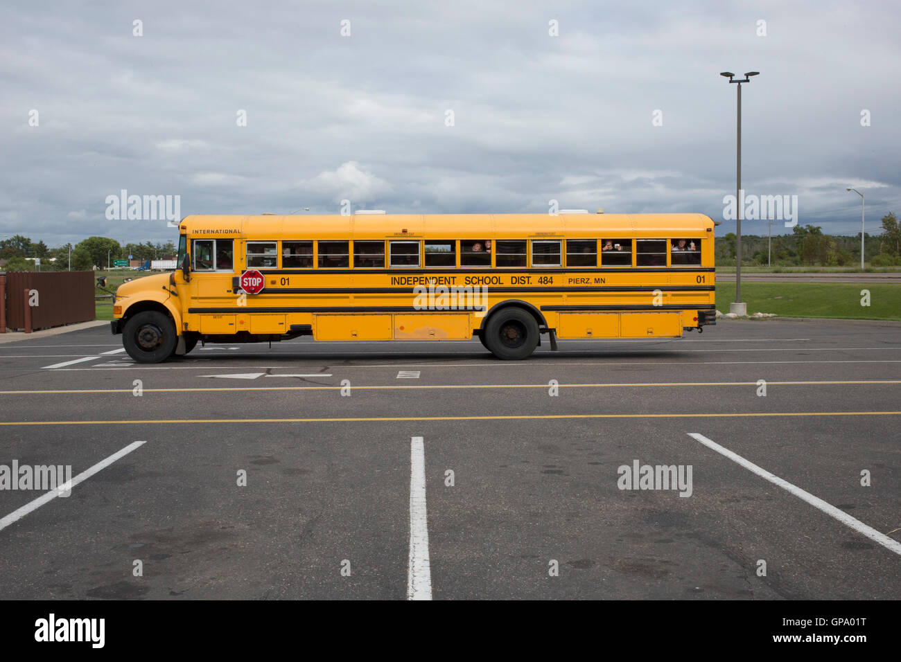 Students gesture as they wait in a parked school bus in a parking lot in Brainerd, Minnesota, USA Stock Photo